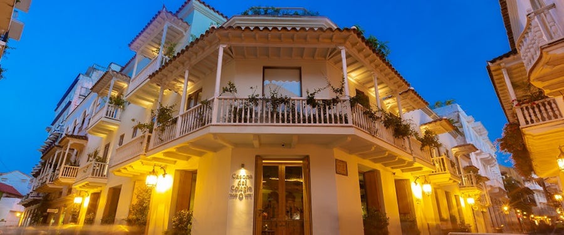 Casona del Colegio glowing at dusk on a colonial Cartagena street